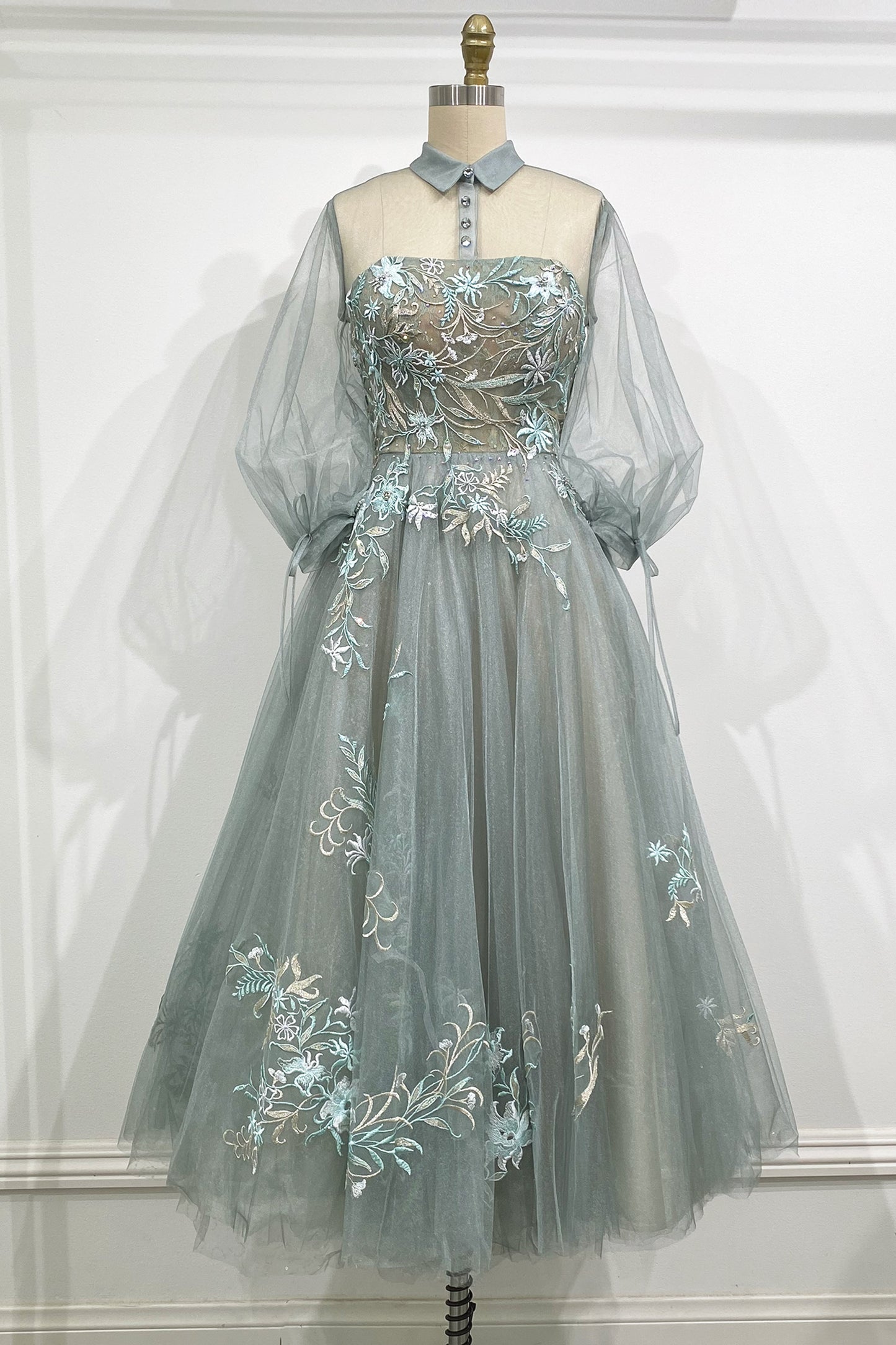 The Duchesa is perfectly appropriate for any special occasion. A fan favorite, this a-line cocktail dress in a beautiful pastel hue features a classic collar with an illusion yoke that connects to a corset-structured bodice overlayed with floral embroider