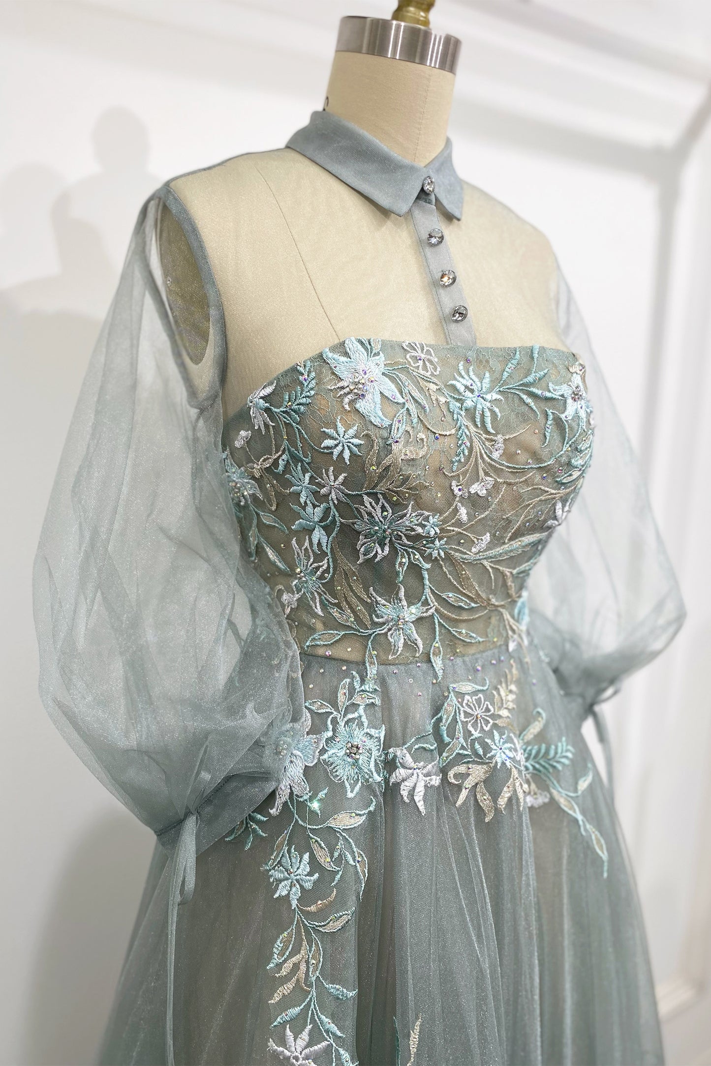 The Duchesa is perfectly appropriate for any special occasion. A fan favorite, this a-line cocktail dress in a beautiful pastel hue features a classic collar with an illusion yoke that connects to a corset-structured bodice overlayed with floral embroider