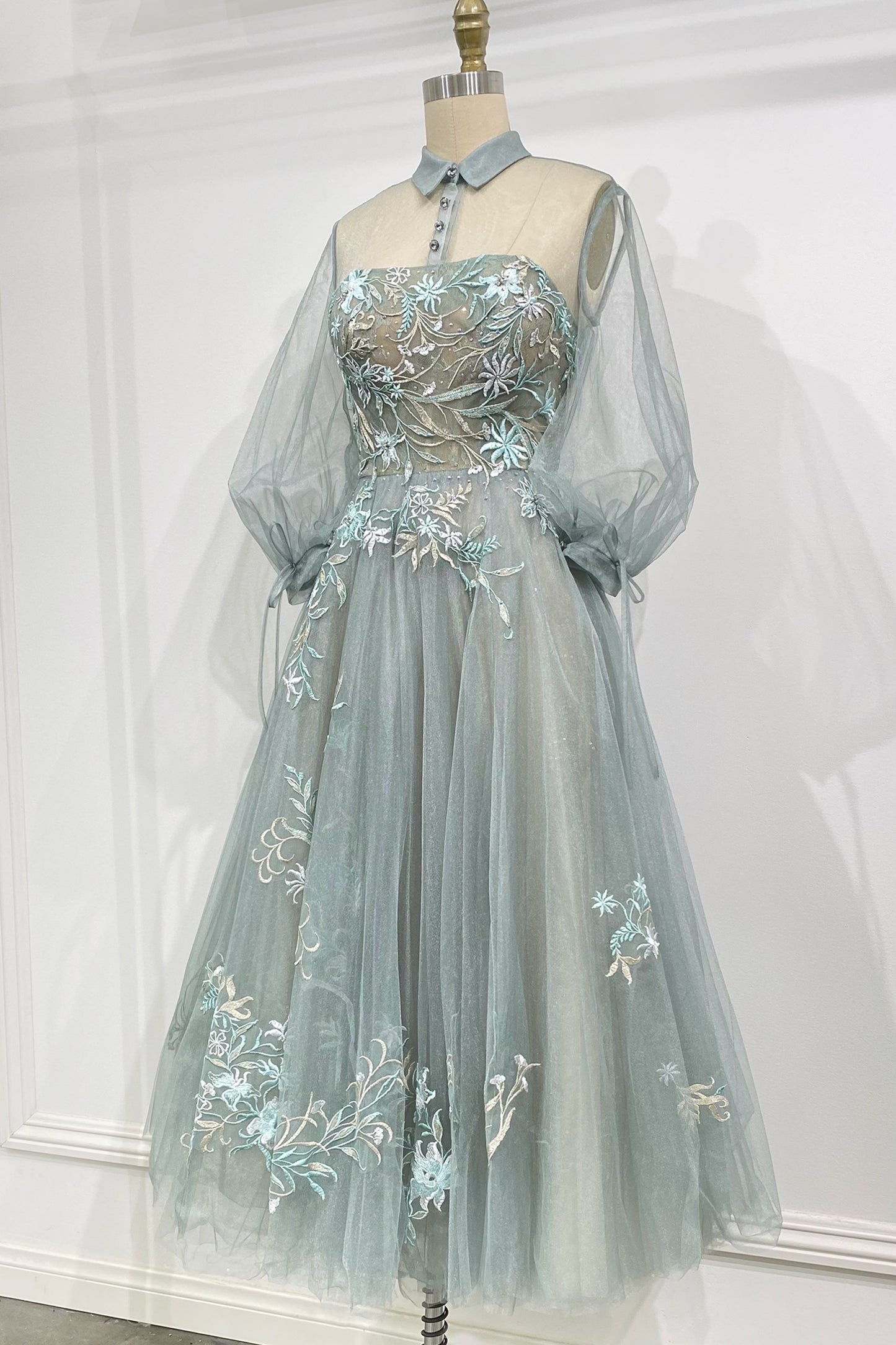 The Duchesa is perfectly appropriate for any special occasion. A fan favorite, this a-line cocktail dress in a beautiful pastel hue features a classic collar with an illusion yoke that connects to a corset-structured bodice overlayed with floral embroider