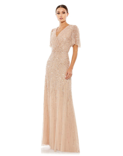 Crafted from beautifully embellished netting, this gown is proof that details matter. The masterpiece is styled with a V-neckline surplice bodice finished with soft pleating, sheer, fluttery sleeves, and a column skirt, all buzzing with the beauty of bead