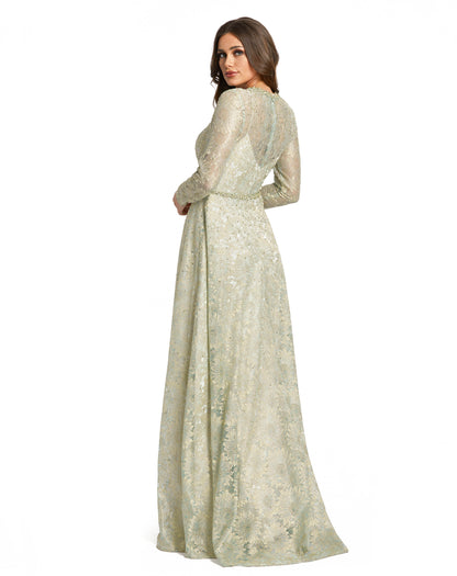 Elegant long-sleeved lace evening gown with an illusion neckline and sleeves, bejeweled neckline, and a flowing a-line skirt. The natural waist is accented by a stunning jeweled belt. Sleeves feature hidden zippers for easy dressing. Mac Duggal Partially