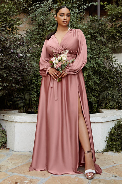 Cut from a soft satin, this floor length gown features romantic split blouson sleeves, a pleated wrap-effect bodice and deep v-neckline. The gathered a-line skirt features a thigh-grazing split so you can show a little leg. This dress is the embodiment of