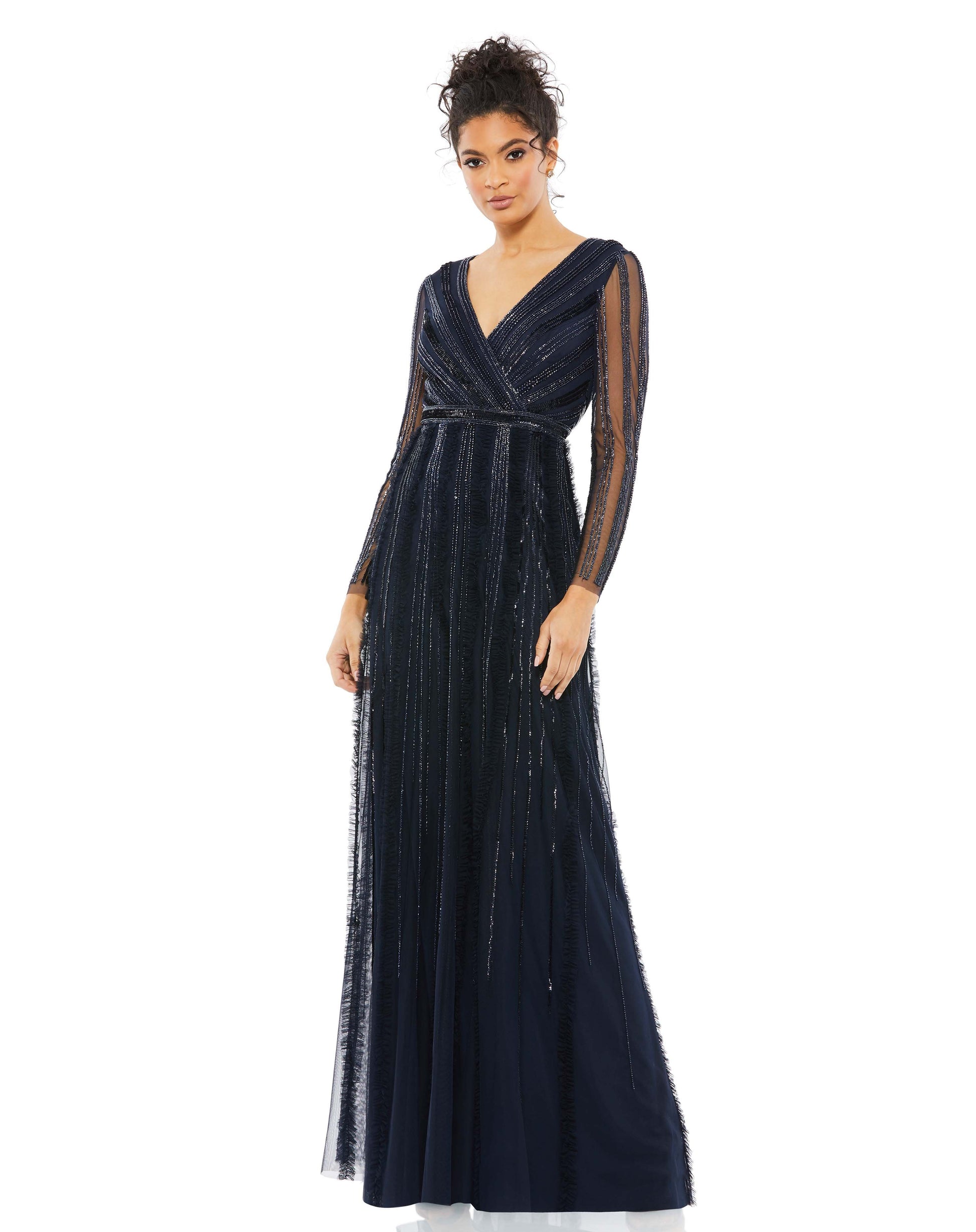 Elegant evening gown with a faux-wrap v-neckline, long illusion sleeves, and a floor-length skirt. The bodice and sleeves feature rows of sequins and beads throughout the mesh, and the skirt is embellished with elongating rows of beads, sequins, and subtl